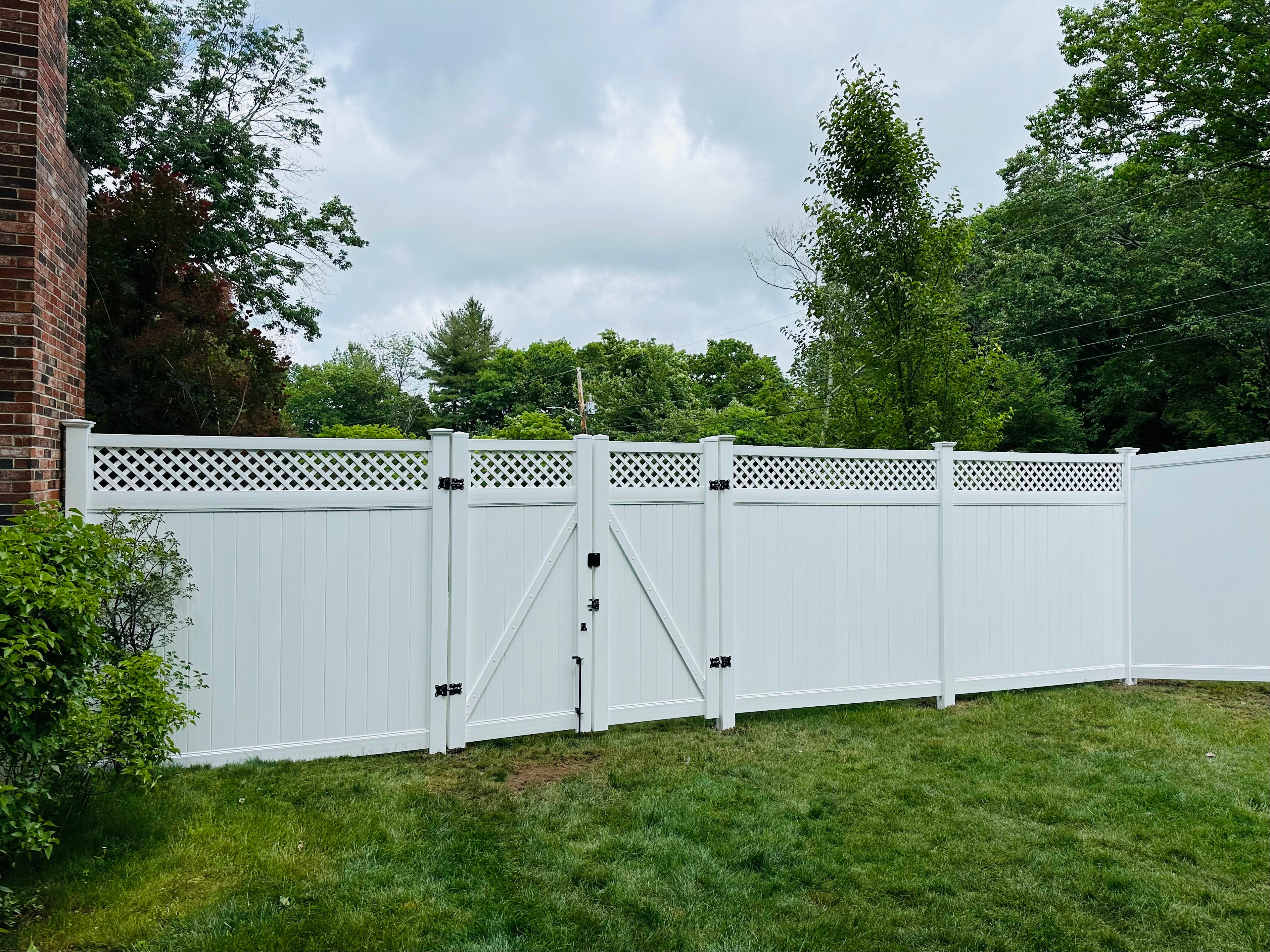 White vinyl privacy fence with lattice top and gate installed by Ultra Fence LLC