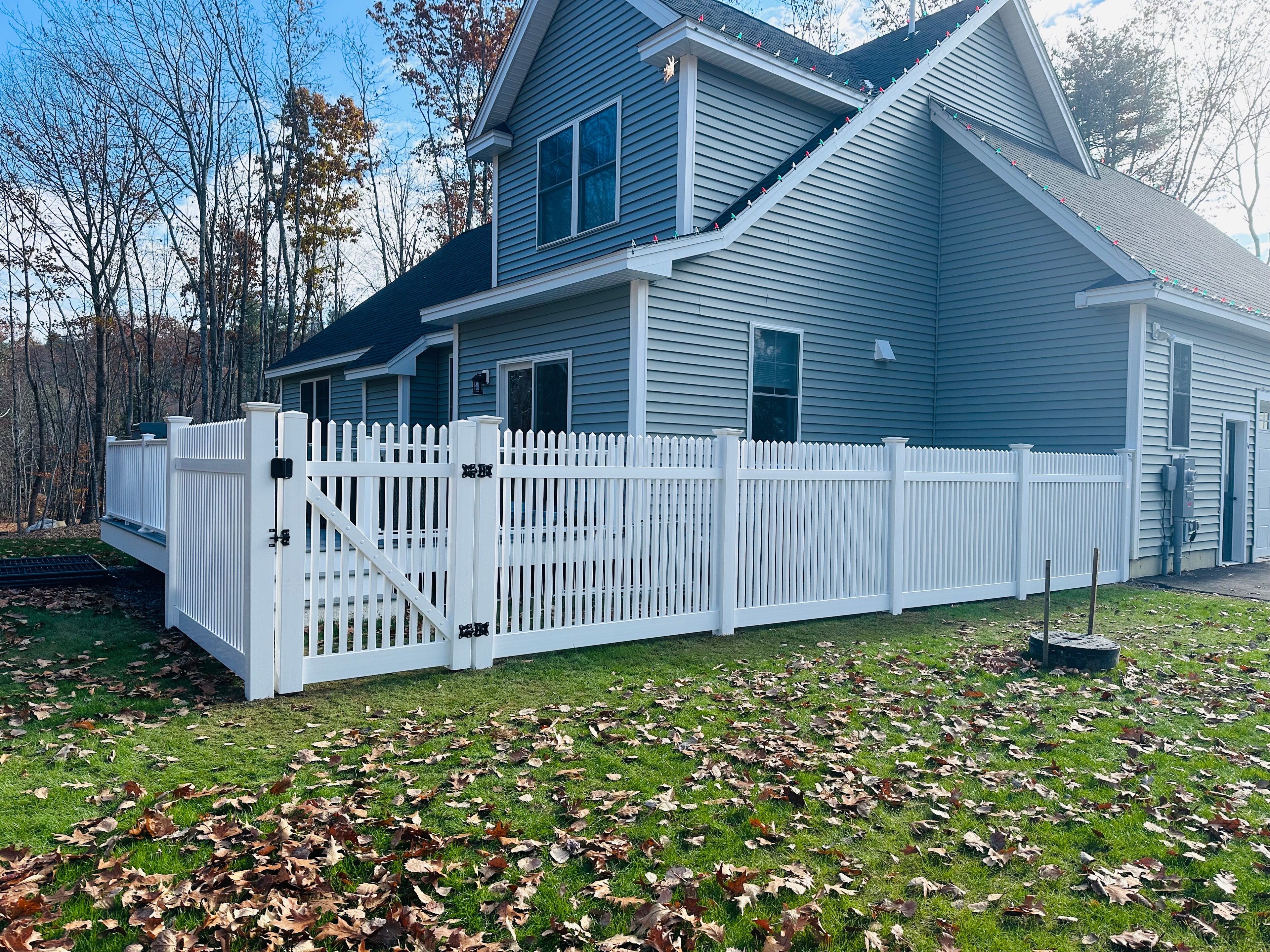 White vinyl picket fence with gate on residential home by Ultra Fence LLC