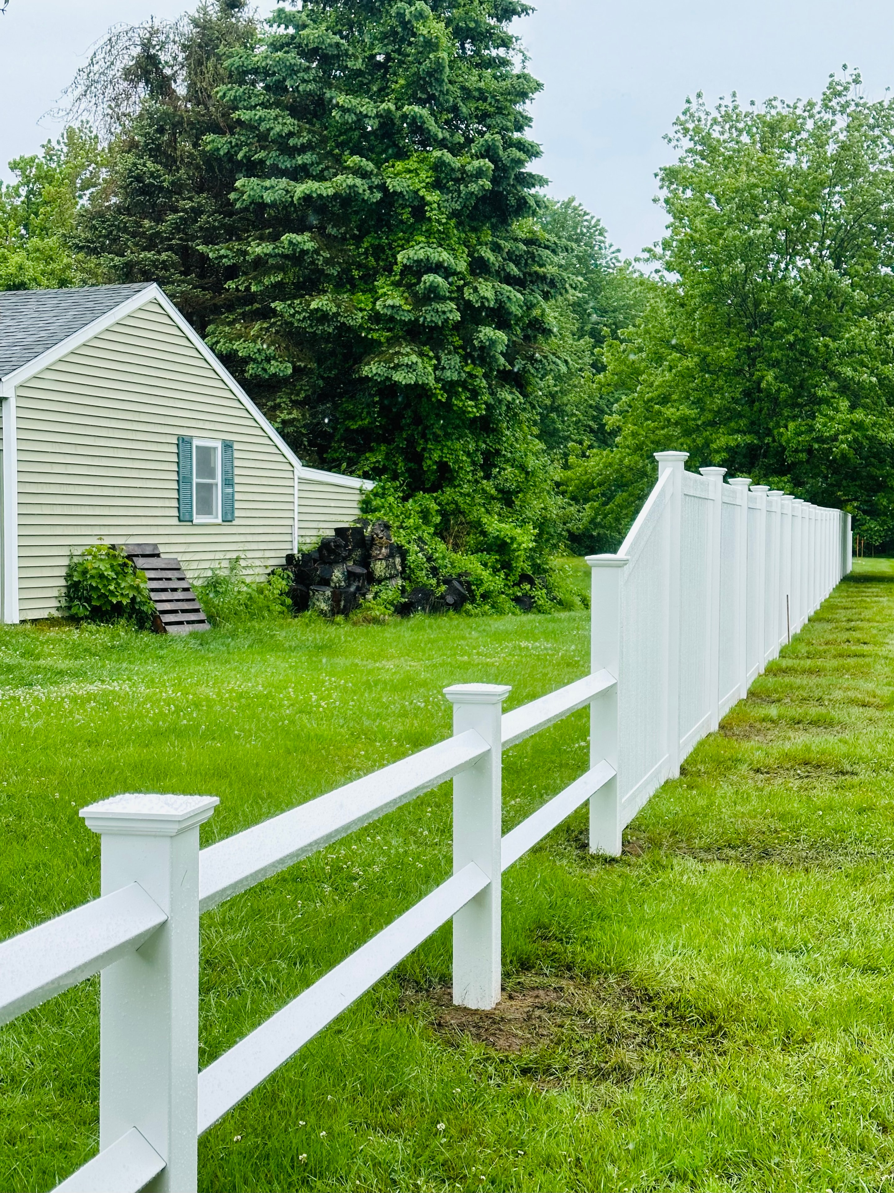 White vinyl split rail and privacy fence combination by Ultra Fence LLC